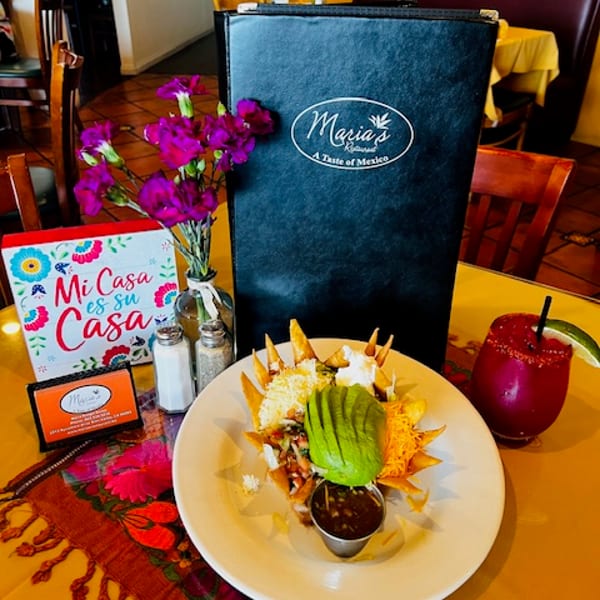 Maria's Restaurant menu, nachos with avocado, and a red drink on a colorful table.